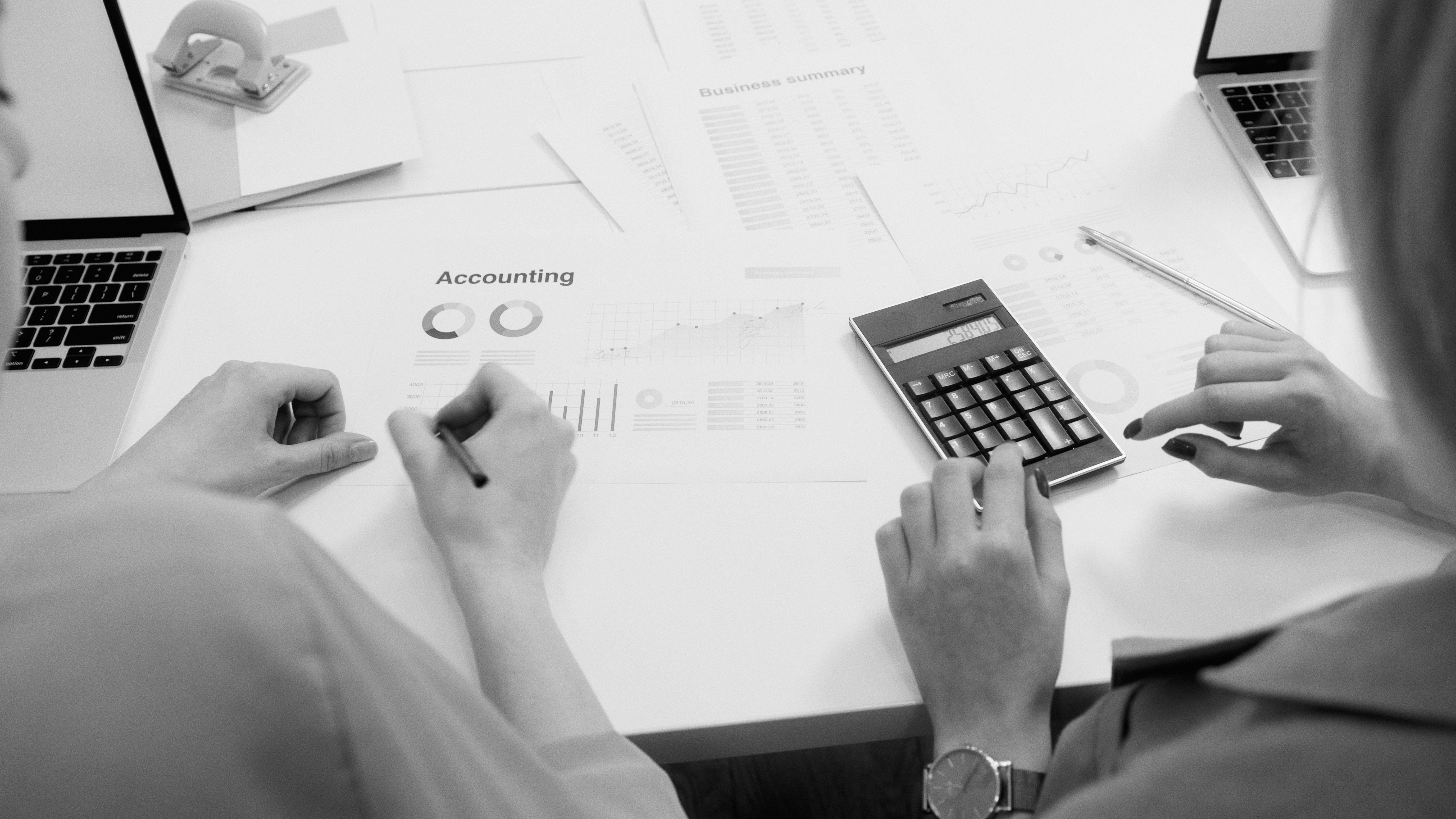 A finance team member reviewing a payroll accrual report on a laptop in a municipal office.