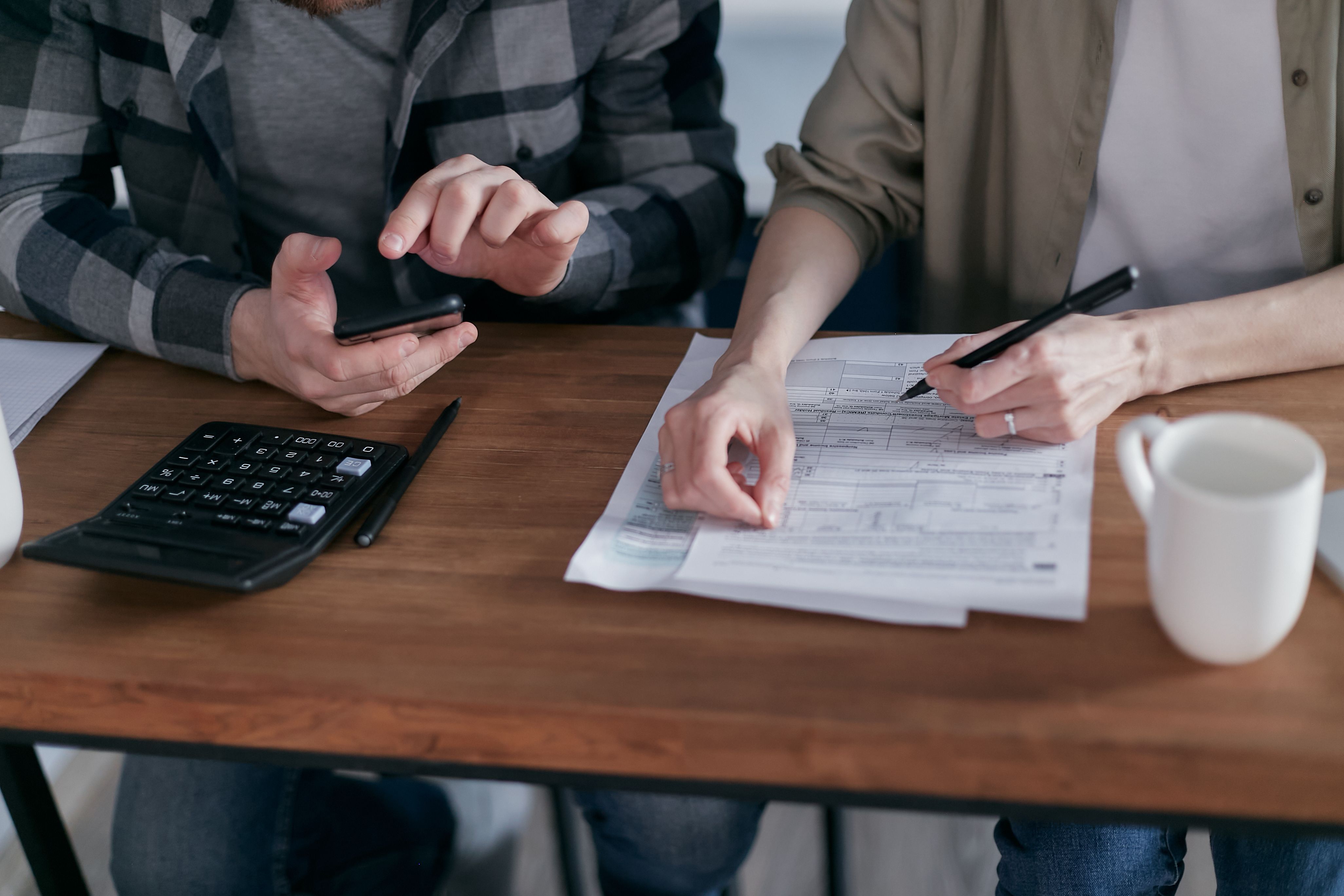 A tax preparer reviewing a signed T183 authorization form on a tablet, with a laptop showing tax software.